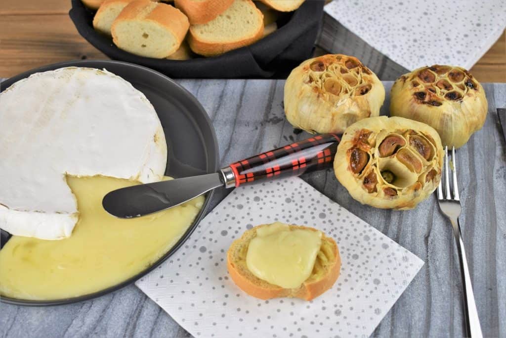 Baked Brie and Roasted Garlic served on a gray board