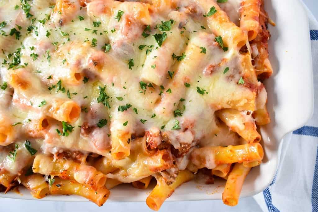 The finished baked ziti in a white casserole dish.