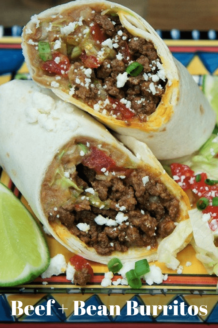 These Beef & Bean Burritos are stuffed with refried beans, flavorful ground beef, shredded lettuce and tomatoes. Then they’re topped with crumbled queso fresco and served with sour cream and green onions on the side. They’re super easy-to-make and delicious. #beefandbeanburritos #burritos #Mexicanfood #southwesternrecipes #Mexican #southwestern #groundbeef