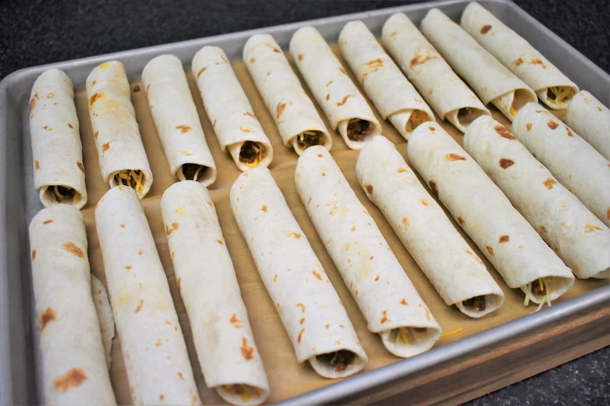Beef Taquitos arranged on a Baking Sheet