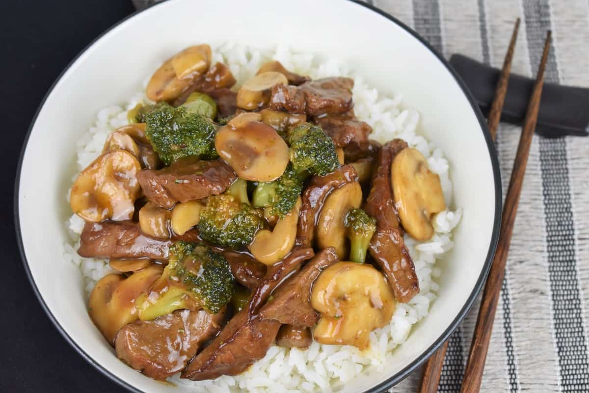 Beef and Broccoli served over white rice in a white bowl