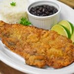 A large thin steak that coated in cracker meal and fried until golden. Served on a large platter with rice, beans and lime wedges.