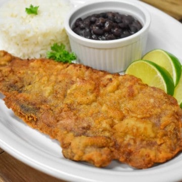 A large thin steak that coated in cracker meal and fried until golden. Served on a large platter with rice, beans and lime wedges.