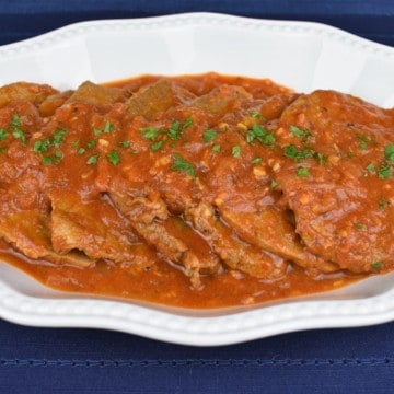 Bistec en Cazuela, thin steaks with a tomato sauce served in a white platter