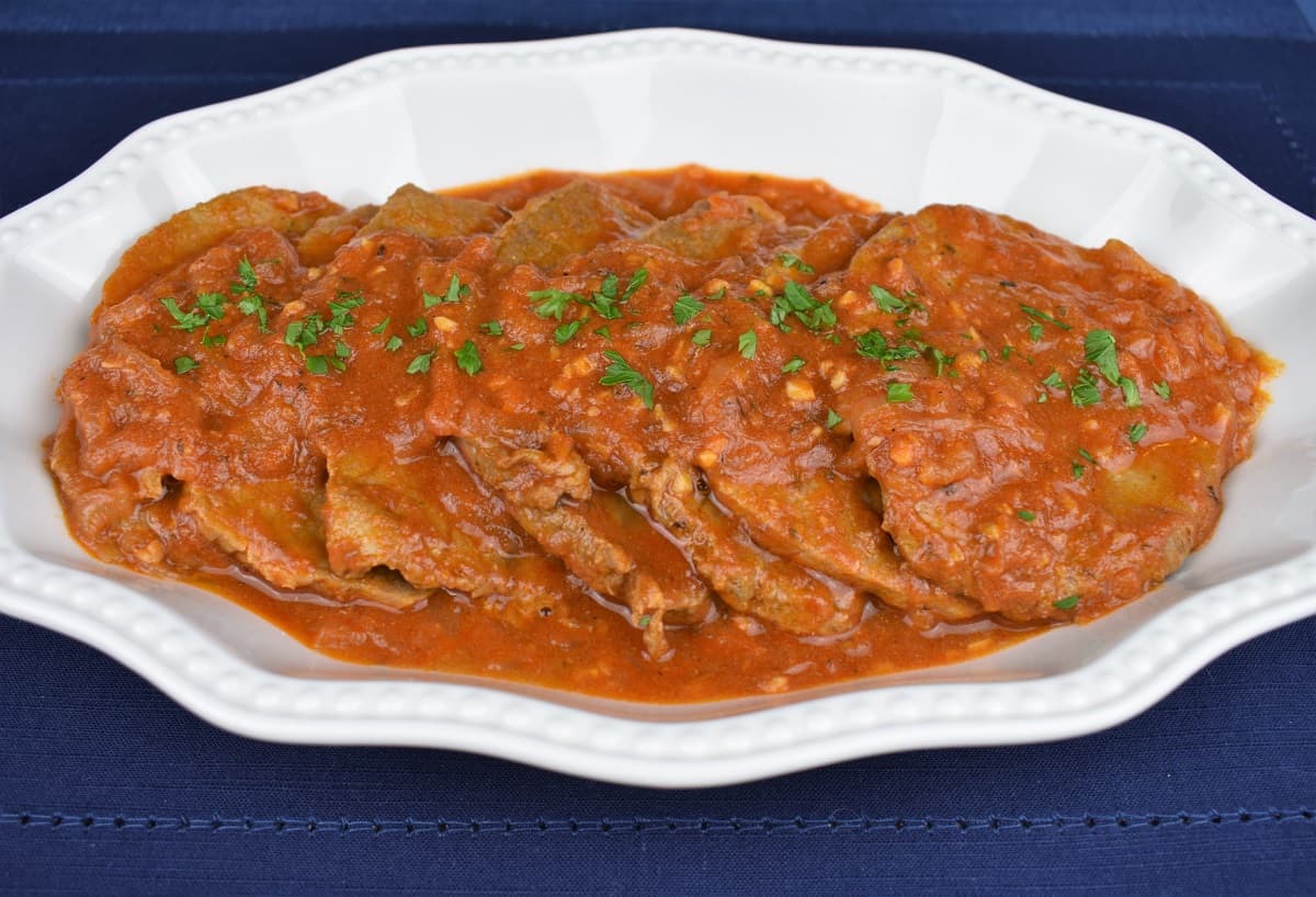 Bistec en Cazuela, thin steaks with a tomato sauce served in a white platter