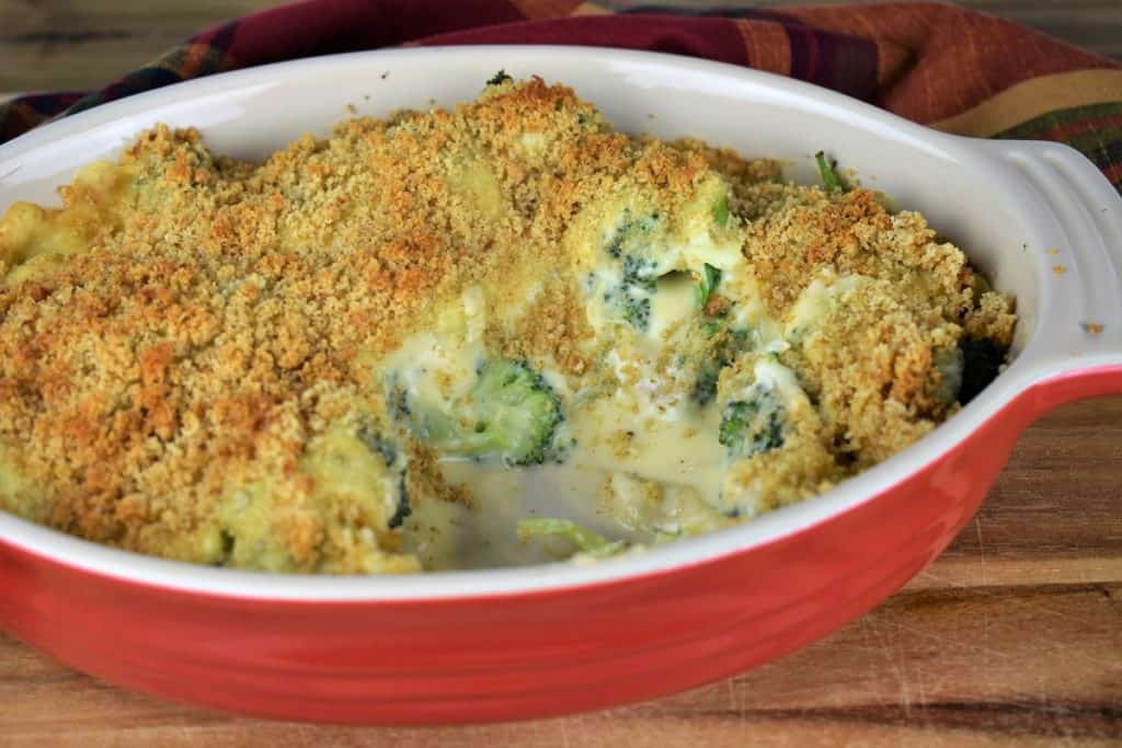 Broccoli Cheese Casserole with some servings missing to expose the broccoli and the creamy sauce