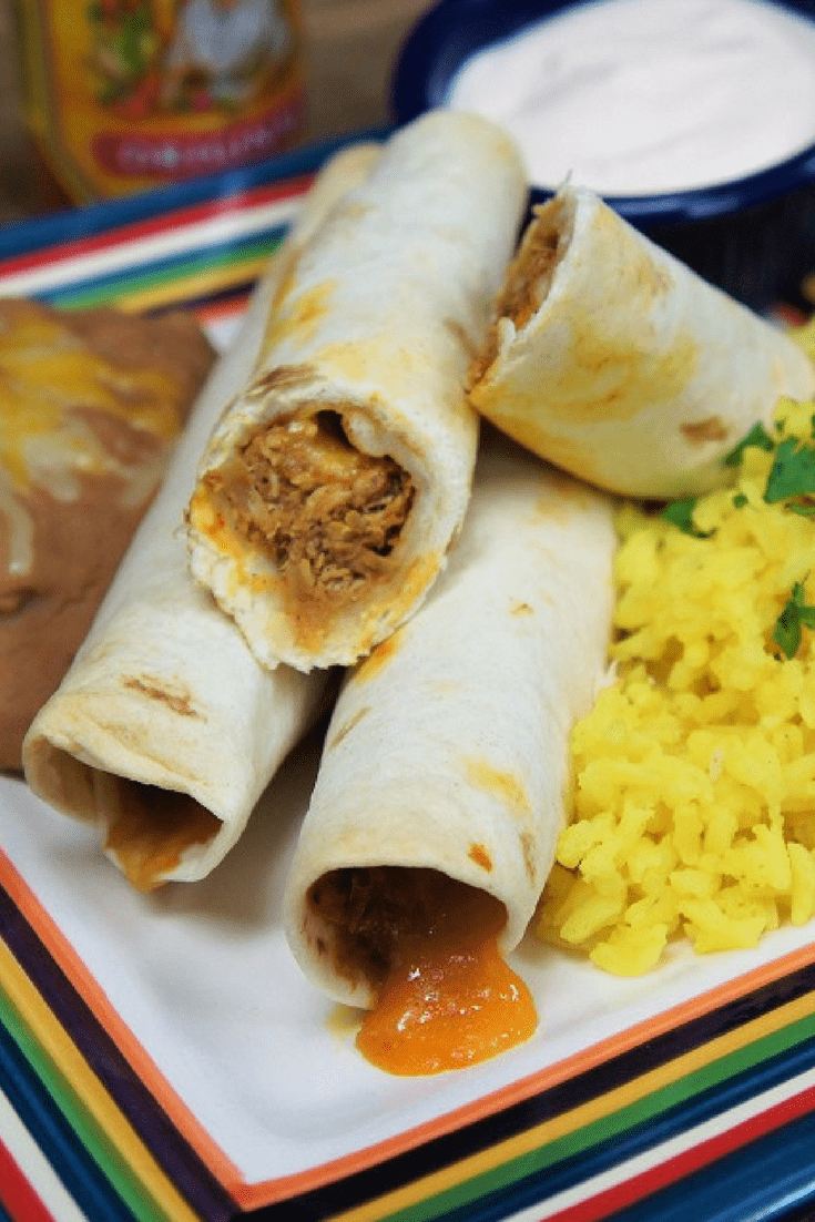 These shredded chicken taquitos are perfect for dinner or as an appetizer. Chicken is cooked in a tomato sauce that’s seasoned with a southwestern inspired spice blend. Then the chicken is shredded and added back to absorb the sauce. We use flour tortillas to wrap the chicken add cheese, then bake them until crispy. #chickentaquitos #taquitos #chicken #Mexicanfood #southwestern #appetizers #gamedayappetizers