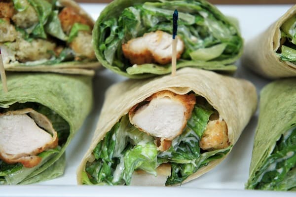 Crispy Chicken Caesar Salad Wraps chopped breaded chicken combined with Caesar salad rolled in thin wraps, cut in half and secured with toothpicks