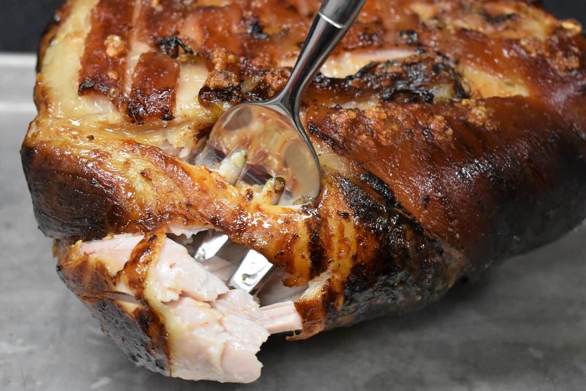 Cuban Roast Pork meat being held by a large fork