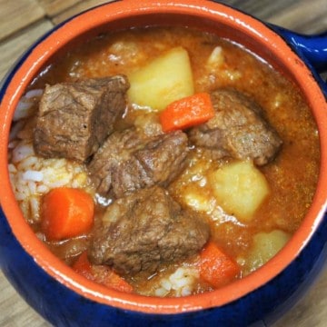 Cuban-Style Beef Soup a thick soup with beef, potatoes and carrots served in a blue crock.