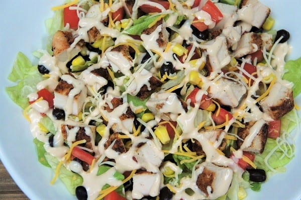 Grilled Chicken Southwestern Salad, a chopped salad loaded with chicken, corn, black beans tomatoes and covered in a drizzle of dressing