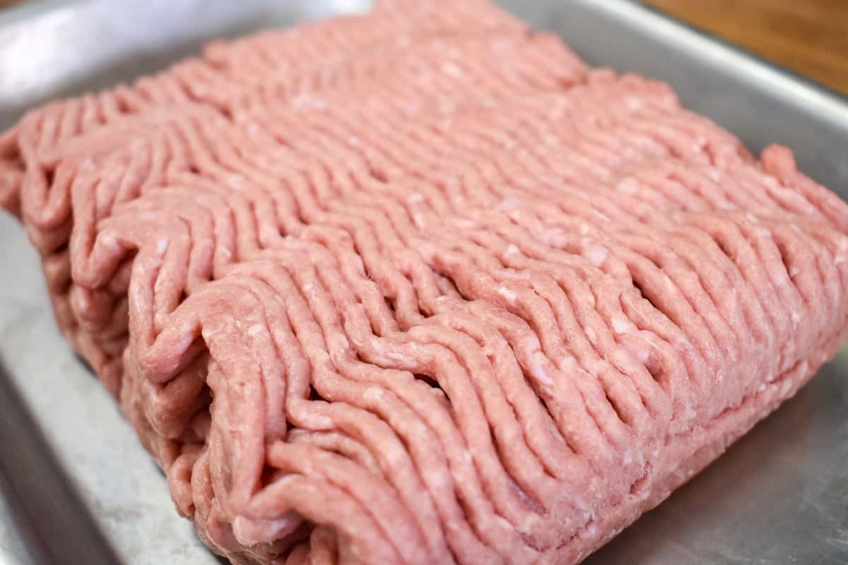 Uncooked ground turkey right out of the package on a small metal sheet pan.