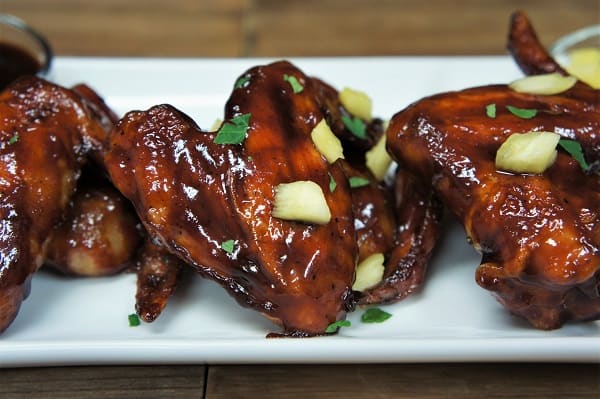 Habanero Chicken Wings garnished with diced pineapple and parsley arranged on a white platter