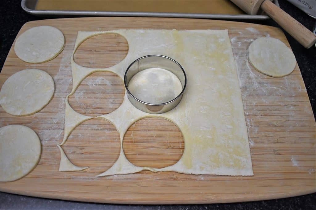 Puff pastry cut into rounds on a lightly floured cutting board