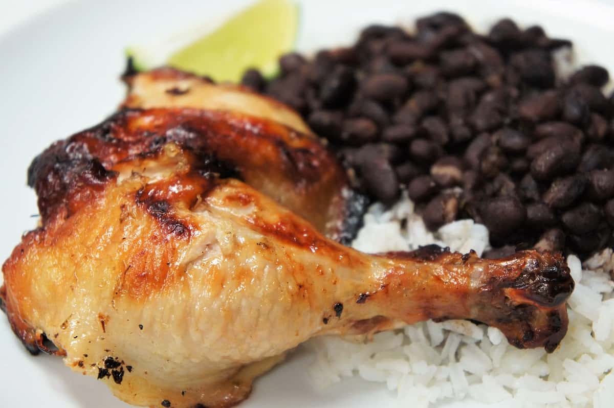 Mojo Marinated Grilled Chicken leg and thigh served with rice and black beans