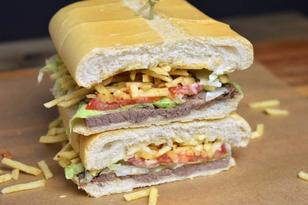 Pan Con Bistec, a thin cut steak served on Cuban bread with lettuce tomatoes and potato sticks