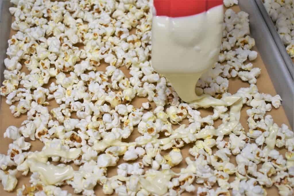 Drizzling White Chocolate on Popcorn using a red spatula