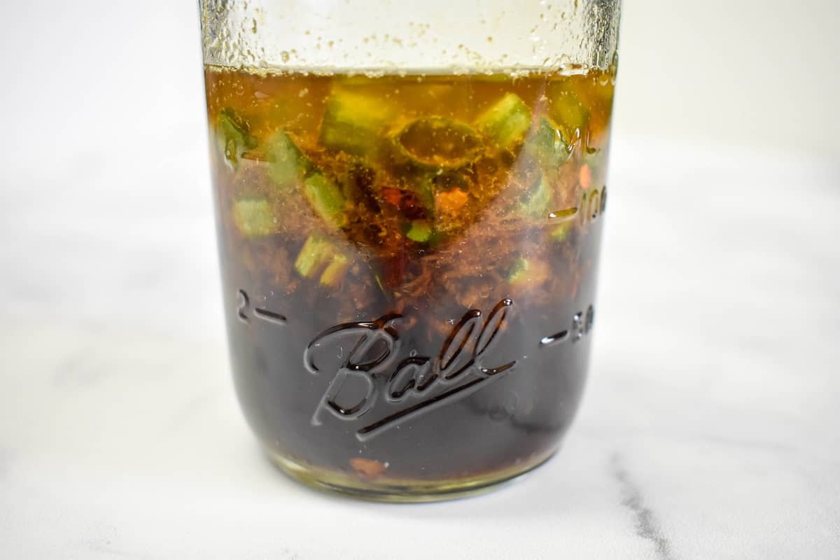 The prepared sesame sauce in a small canning jar displayed on a white table.