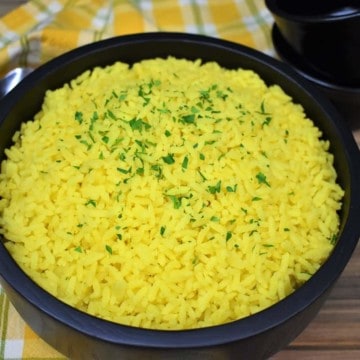 Yellow rice served in a large black serving bowl.
