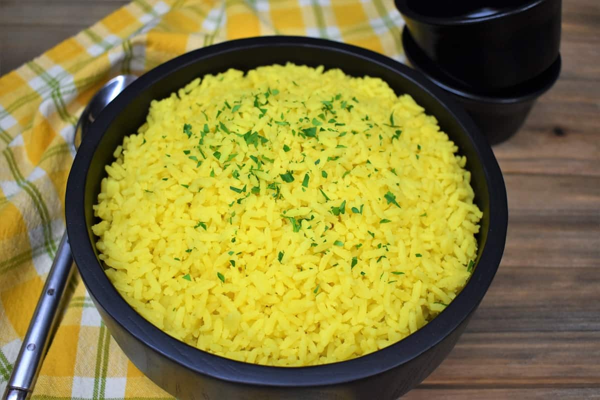 Yellow rice served in a large black serving bowl.