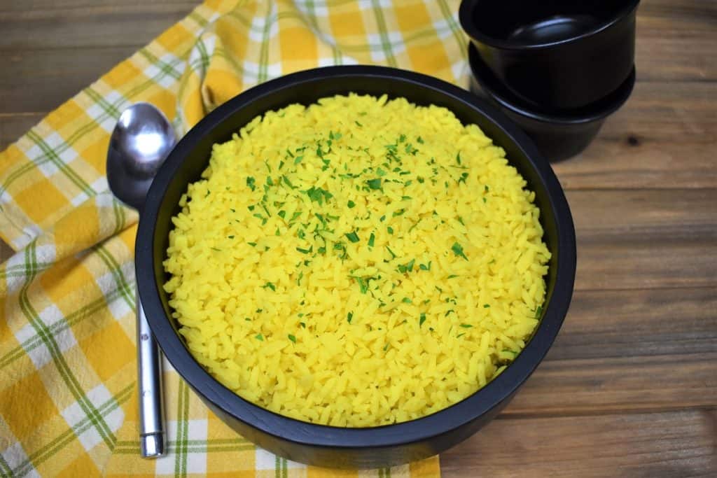 Yellow rice served in a large black serving bowl.