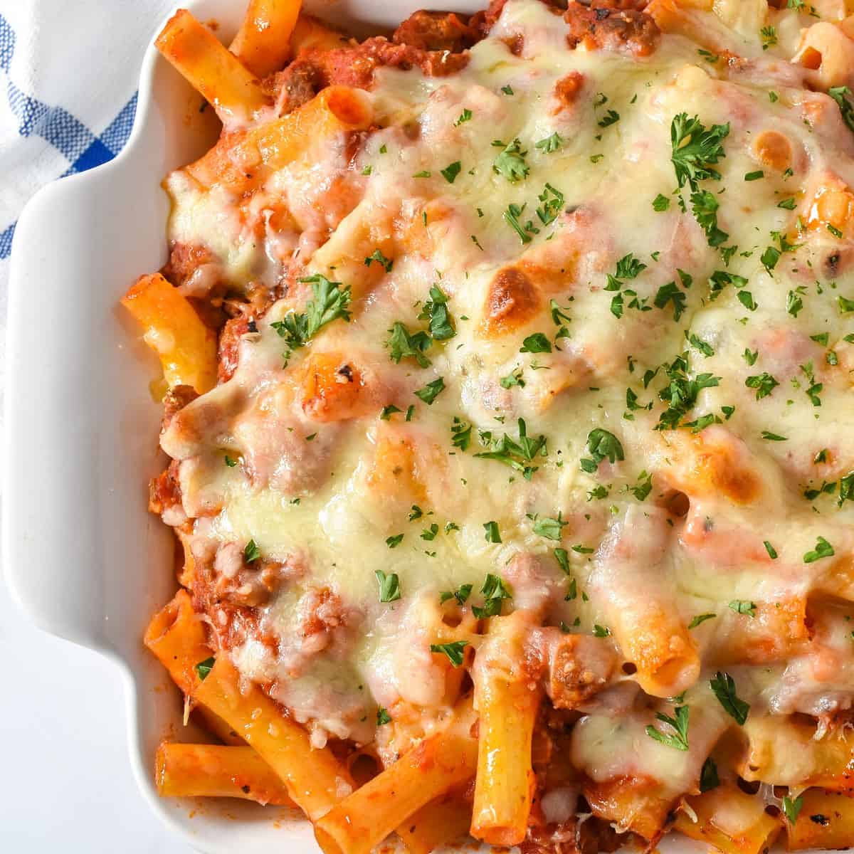 The finished baked ziti in a white casserole dish.