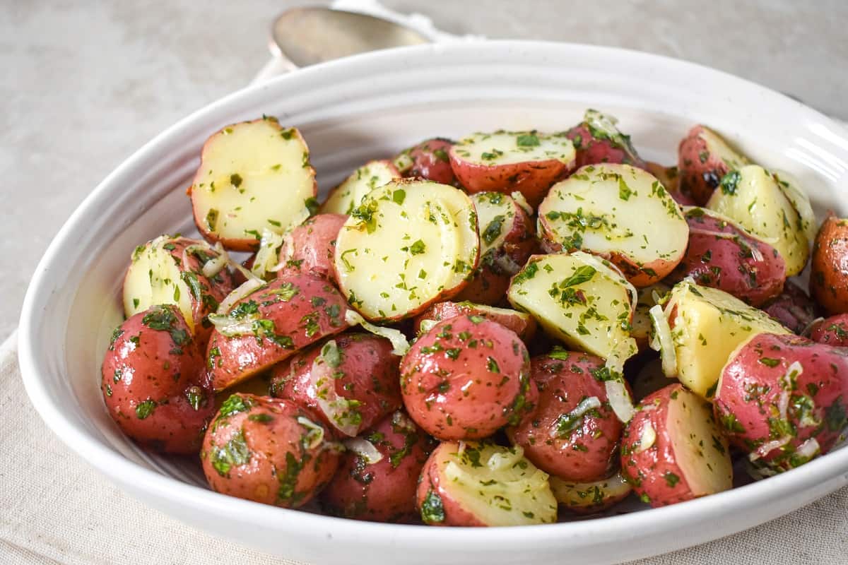 The finished potatoes in a white, oval bowl.