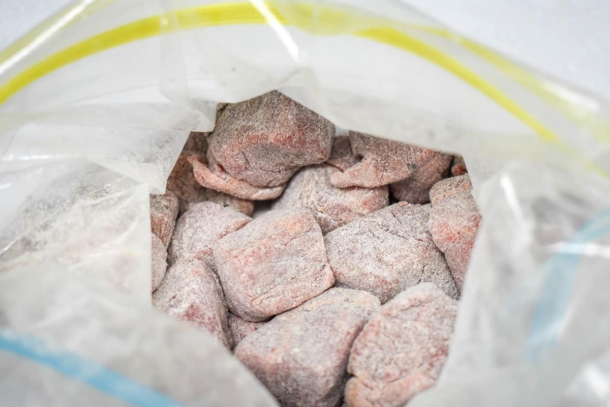 Beef chunks lightly coated in flour in a zip top bag.