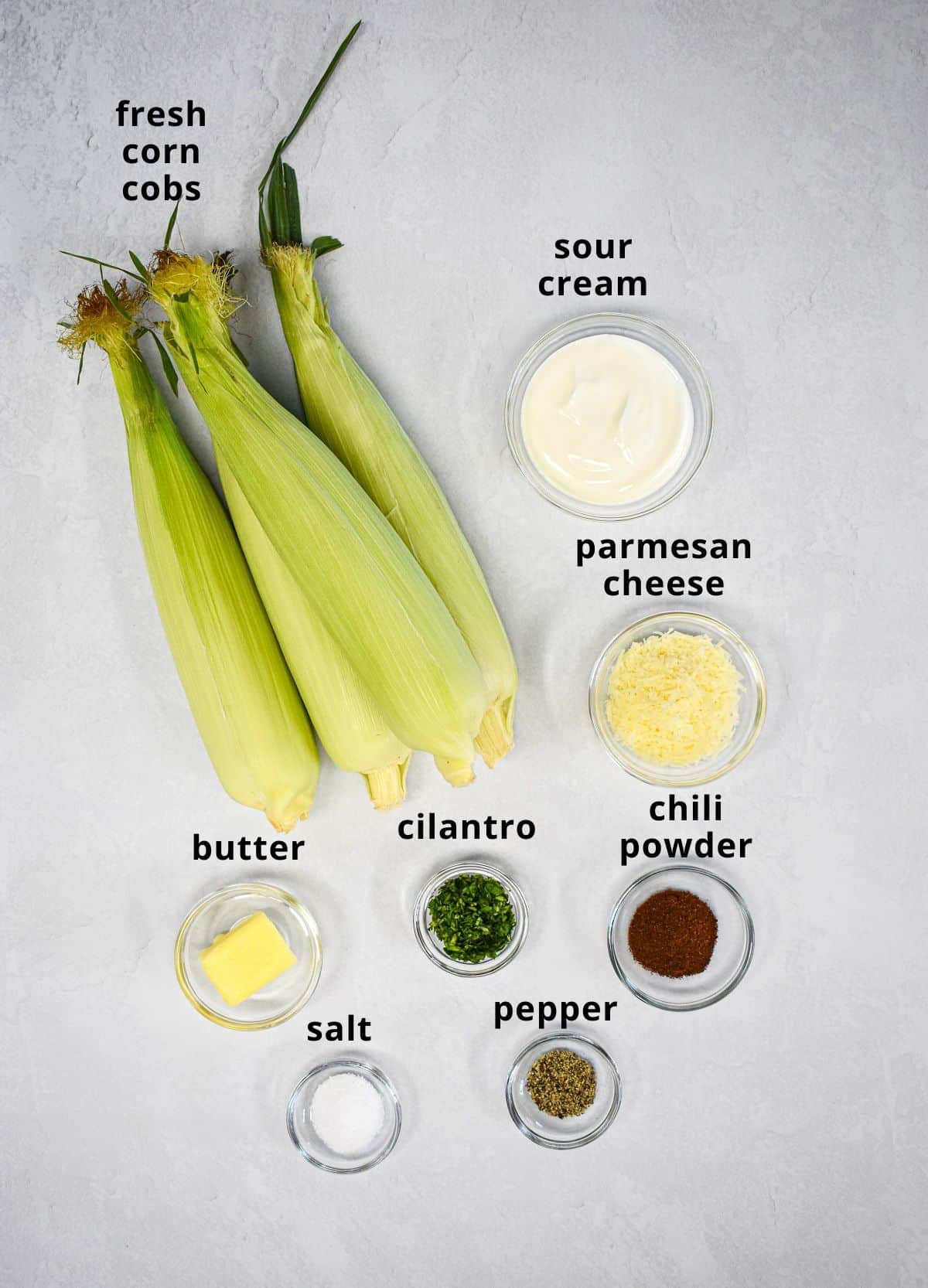 The ingredients for the recipe arranged on a white table with each labeled with small black letters.