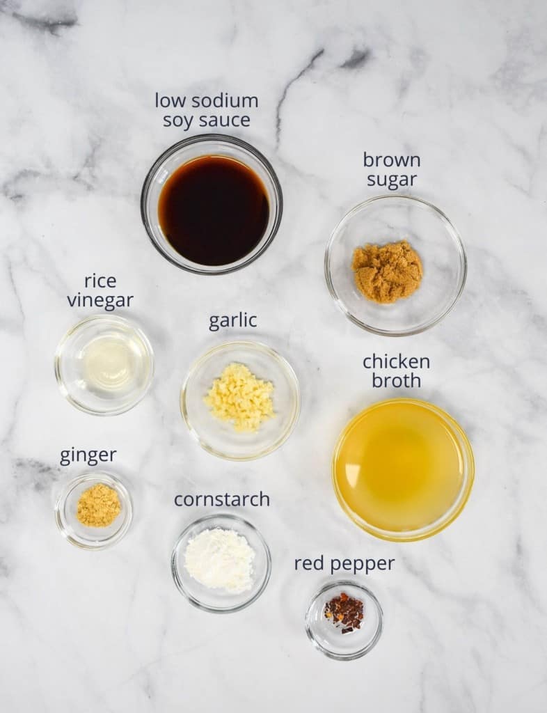 The ingredients for the sauce arranged in small glass bowls and arranged on a white table.