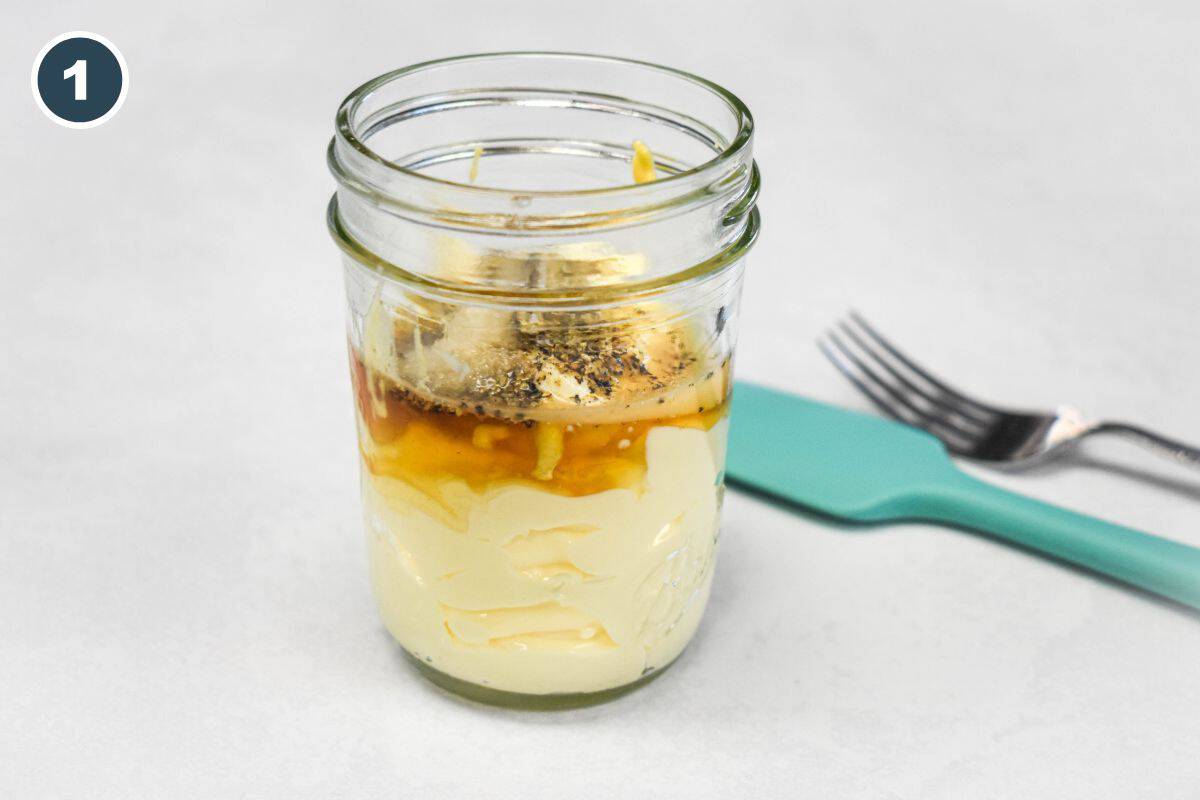 Mayonnaise, Dijon mustard, apple cider vinegar, honey, salt, and black pepper in a jar for chicken salad dressing.