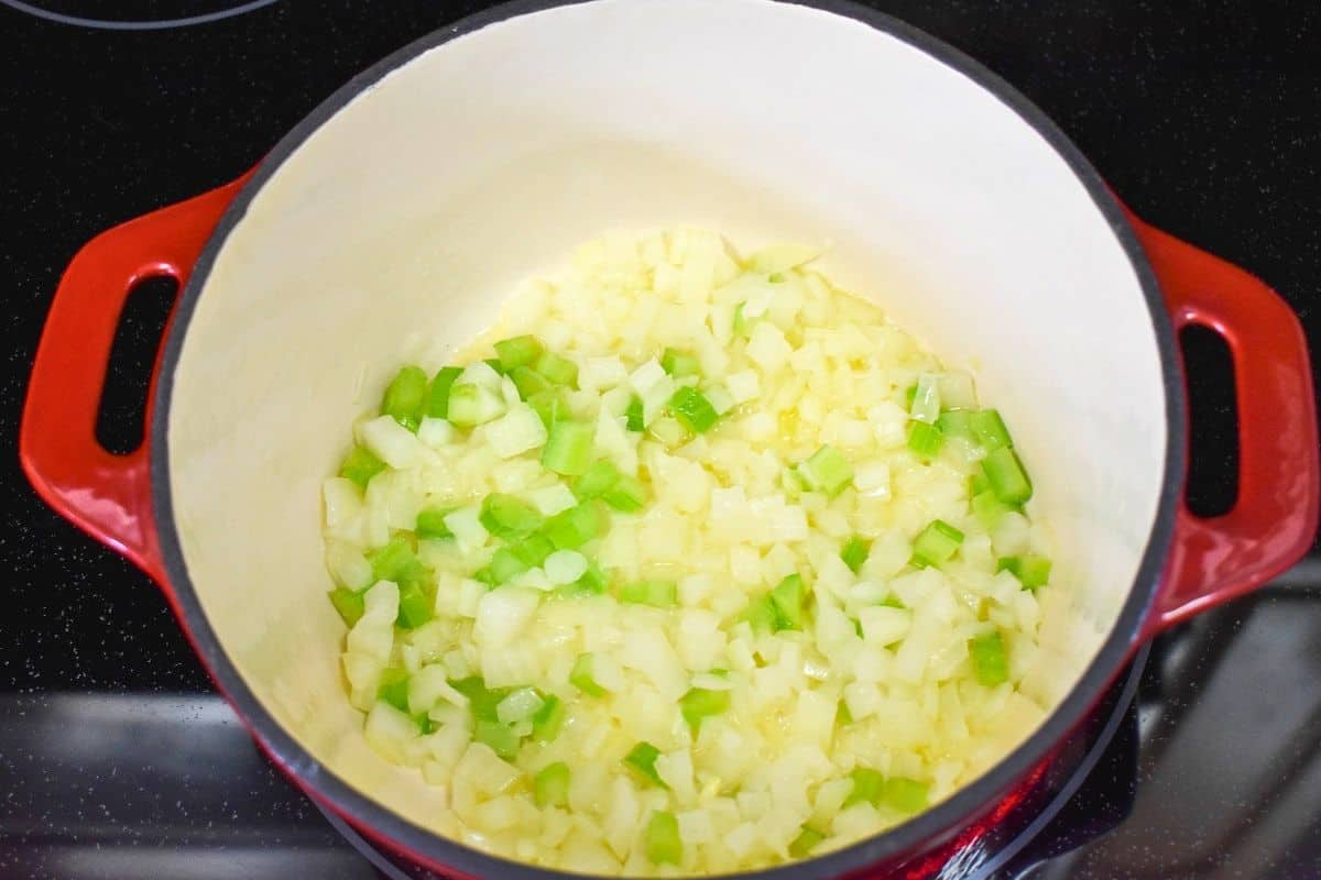 Onion and celery sautéing in olive oil and butter in a pot.