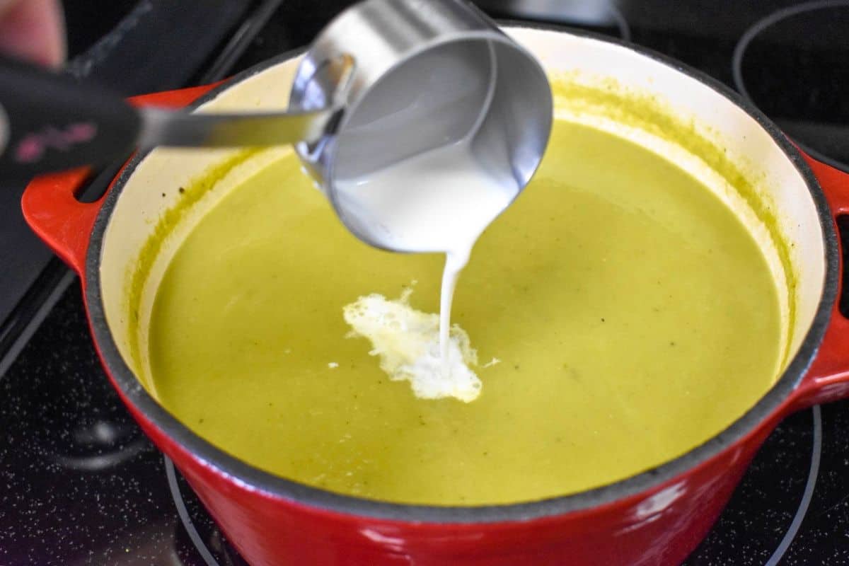 Half-and-half being added to puréed cream of asparagus soup.