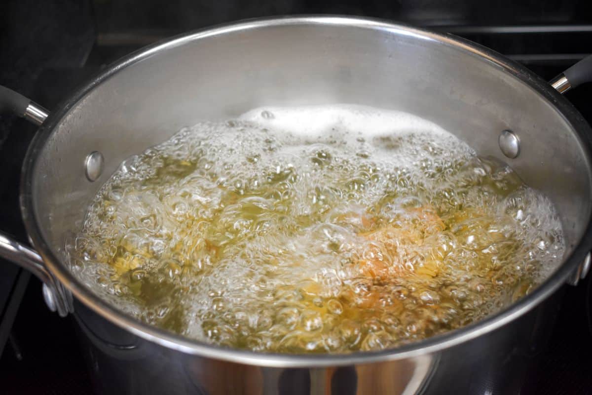 Tricolor rotini pasta cooking in a pot of boiling water.