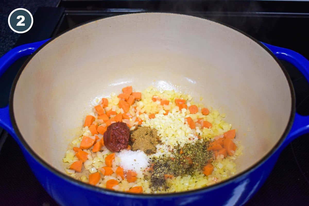 Tomato paste, garlic, and seasonings added to the vegetables.
