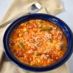 An image of the pastina soup served in a blue bowl with a beige linen.