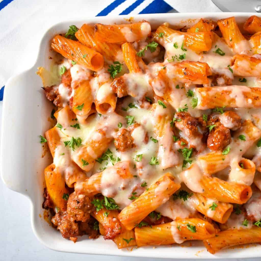 The baked Italian sausage rigatoni bake in a white casserole dish.