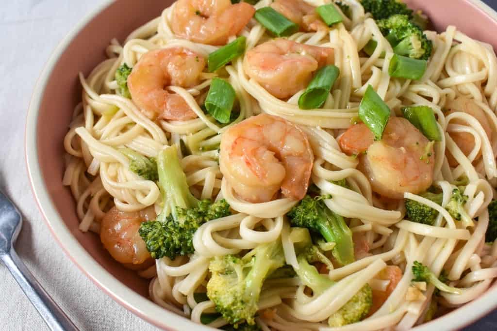 A close up image of the shrimp lo mein served in a pink bowl.