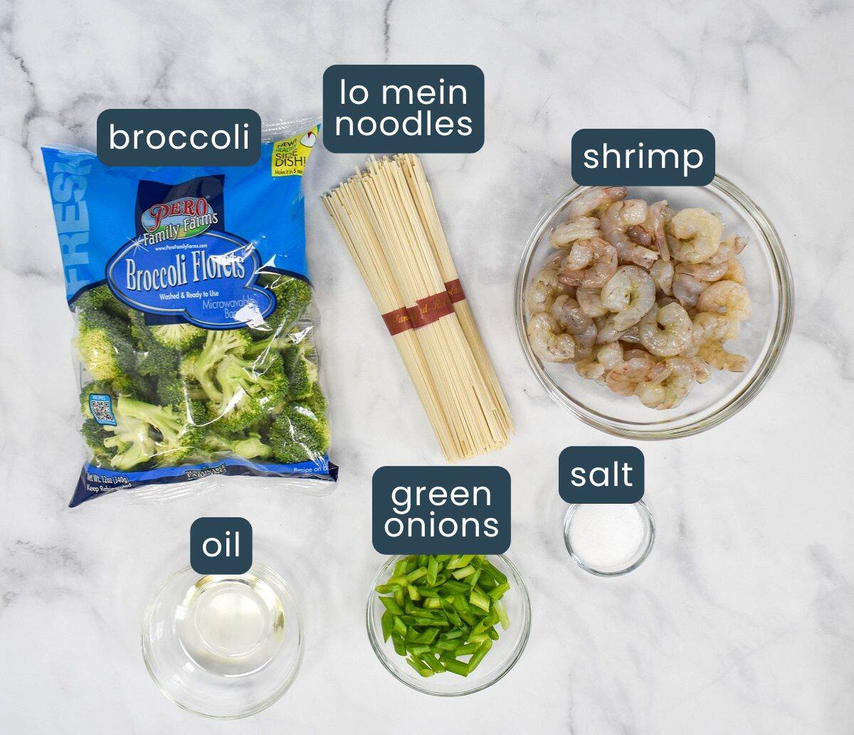 Ingredients for shrimp lo mein, including broccoli florets, lo mein noodles, raw shrimp in a bowl, green onions, vegetable oil, and salt, each labeled.