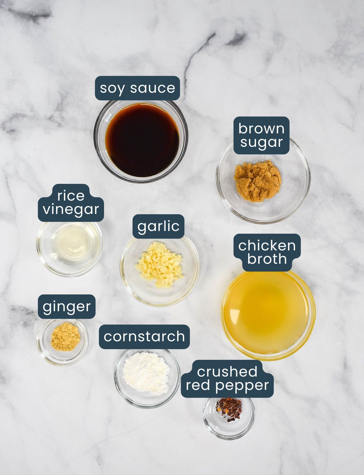 Ingredients for shrimp lo mein sauce, including soy sauce, brown sugar, rice vinegar, minced garlic, chicken broth, ground ginger, cornstarch, and crushed red pepper, each labeled.