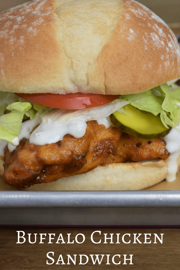 In this Buffalo chicken sandwich, chicken breasts are coated in seasoned flour and fried until golden on the outside, and juicy on the inside. Then they’re tossed in a simple Buffalo sauce and served with lettuce, tomatoes, pickles and blue cheese dressing. #buffalochickensandwich #buffalochicken #buffalosauce #chicken #sandwiches #gamedayfood