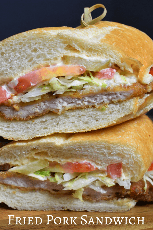 In this fried pork sandwich, thin pork loin chops are simply seasoned, breaded and fried until golden on the outside and juicy on the inside. Then they’re served on a large roll with a spicy mayo, lettuce, tomatoes, and pickles. #friedporksandwich #pork #porkloin #friedpork #sandwiches