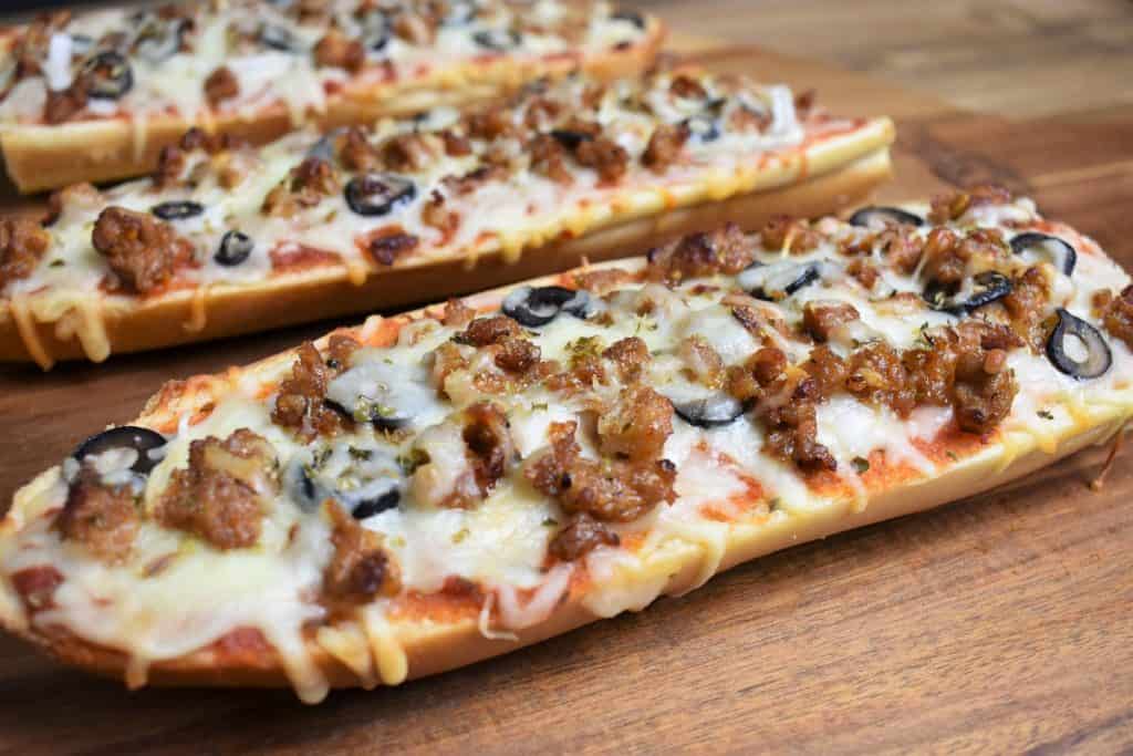 Hot Sausage French Bread Pizza served on a wood cutting board