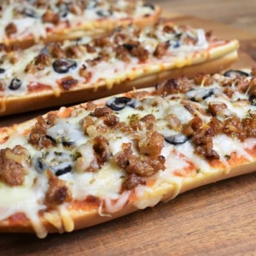 Hot Sausage French Bread Pizza served on a wood cutting board