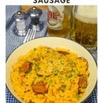 Spanish Rice with Chicken and Sausage served in a white bowl and displayed on a blue checkered cloth with a beer in the background.