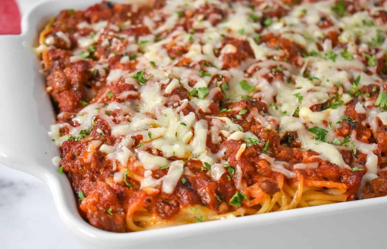 The finished baked spaghetti in a white casserole dish.