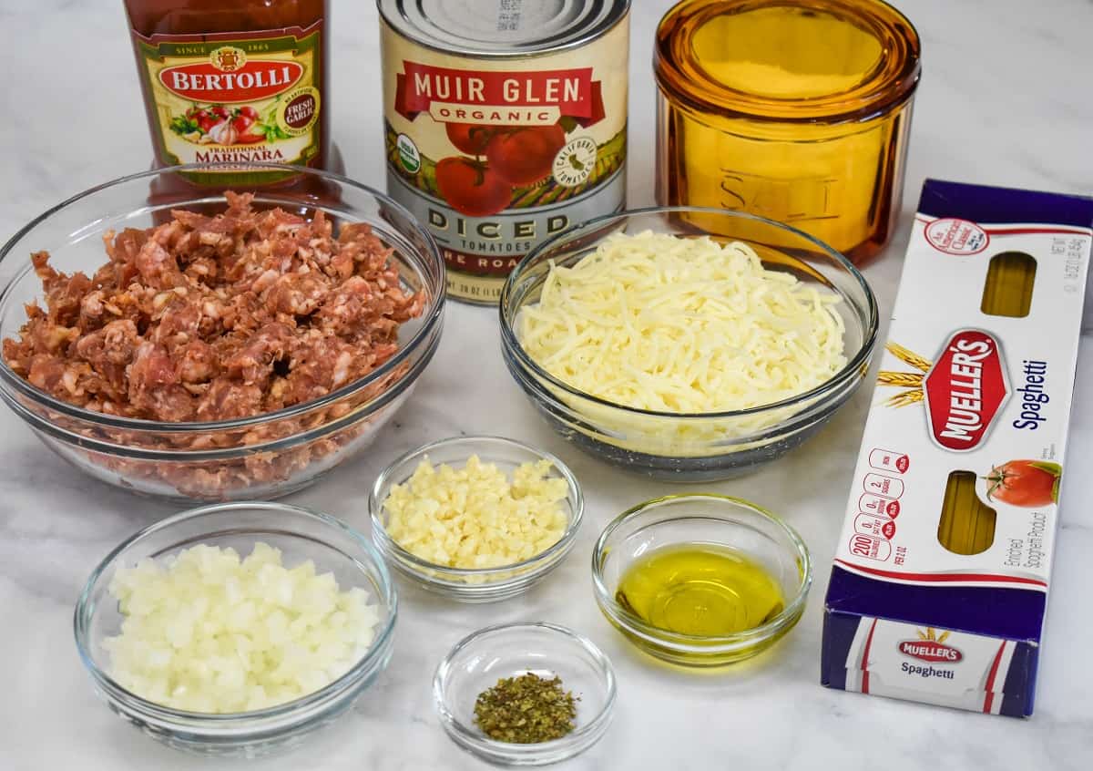 The ingredients for the dish prepped and separated into glass bowls, arranged on a white table.