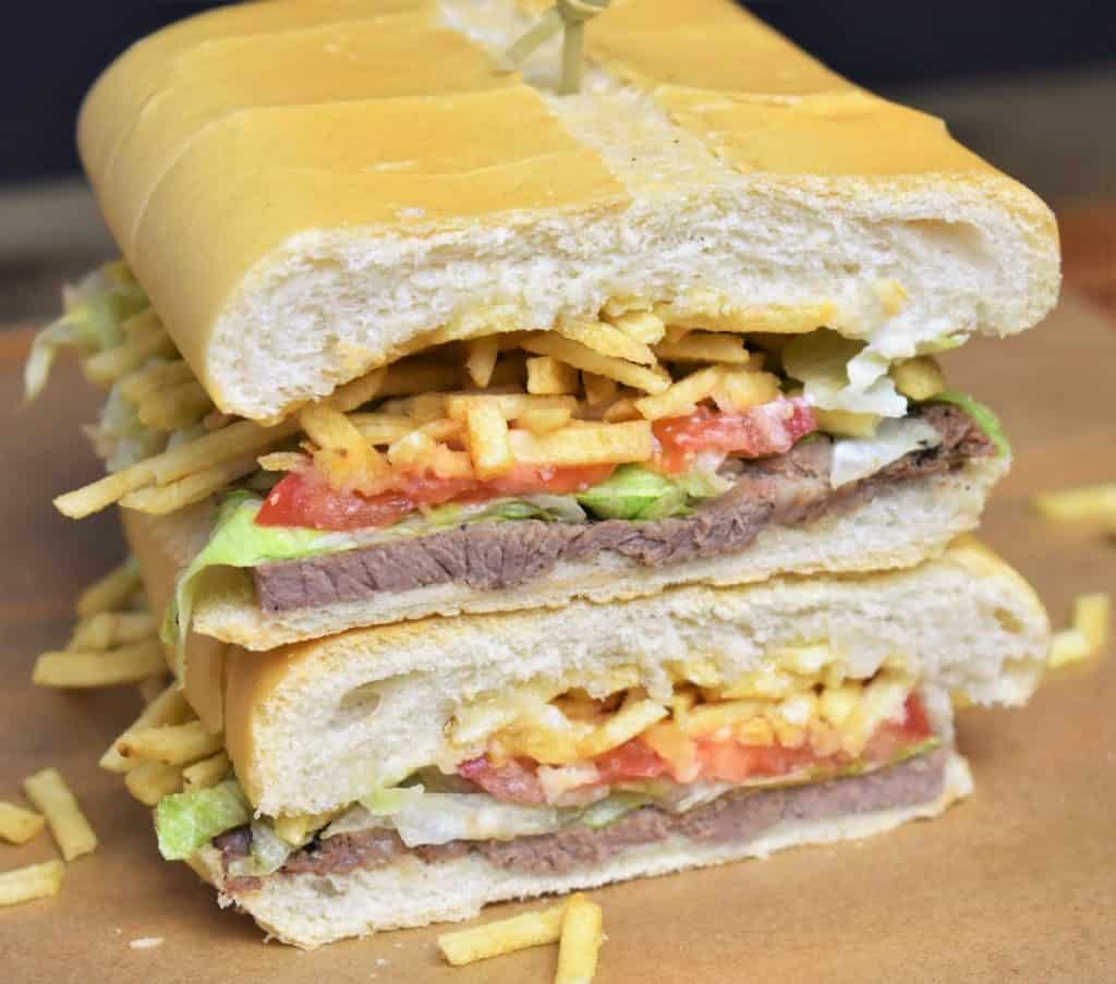 Pan con Bistec sandwich cut in half and stacked.