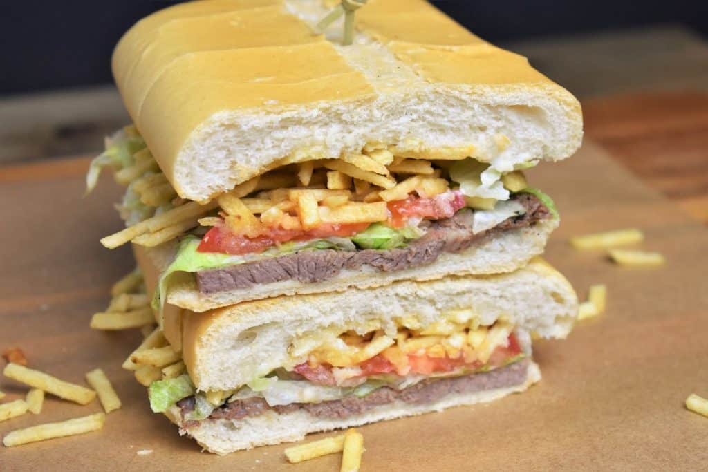 Pan con Bistec sandwich cut in half and stacked.