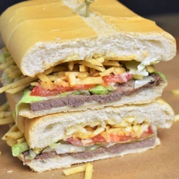 Pan con Bistec sandwich cut in half and stacked.